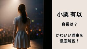 コンサート会場のバックステージで、後ろ向きの女性がステージ袖からライトへ歩き出す瞬間。無地のワンピース衣装、逆光でヘアラインが縁どられ、客席はボケた光の海に見える