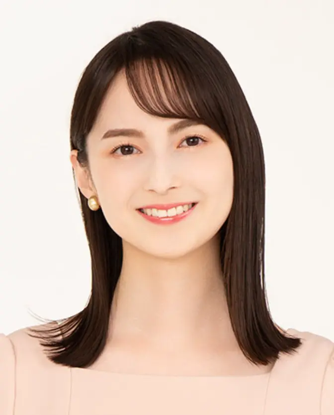 正面を向いて明るく微笑む山本恵里伽アナウンサー。ミディアムヘアで、ピンクベージュの衣装とゴールドのイヤリングを着用。背景は白。