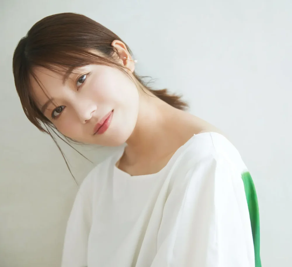 横山由依さんの公式プロフィール写真。白いトップスを着用し、優しく微笑む横顔のポートレート。