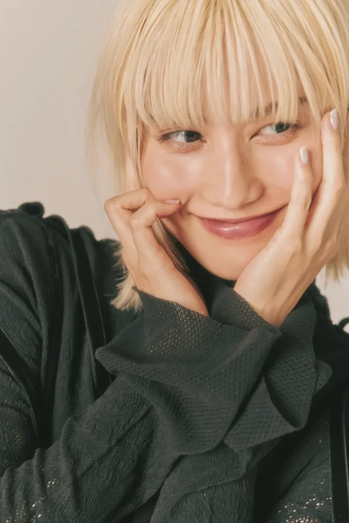 ブロンドのショートヘアでチャーミングに微笑む、女優の橋本愛さんをイメージしたポートレート画像。